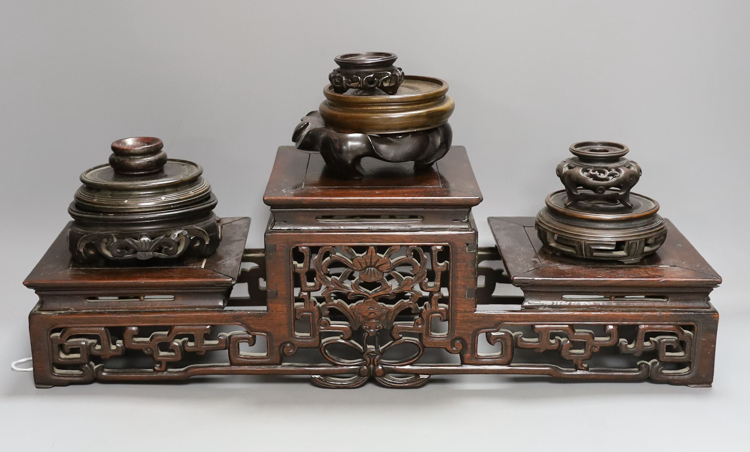 A Chinese carved hardwood 3 tier stand, late Qing, together with other similar stands. Largest 49cm